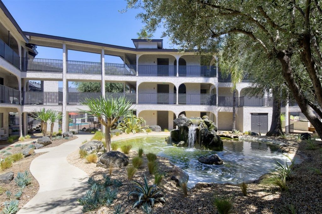 A large building with a waterfall in front of it.