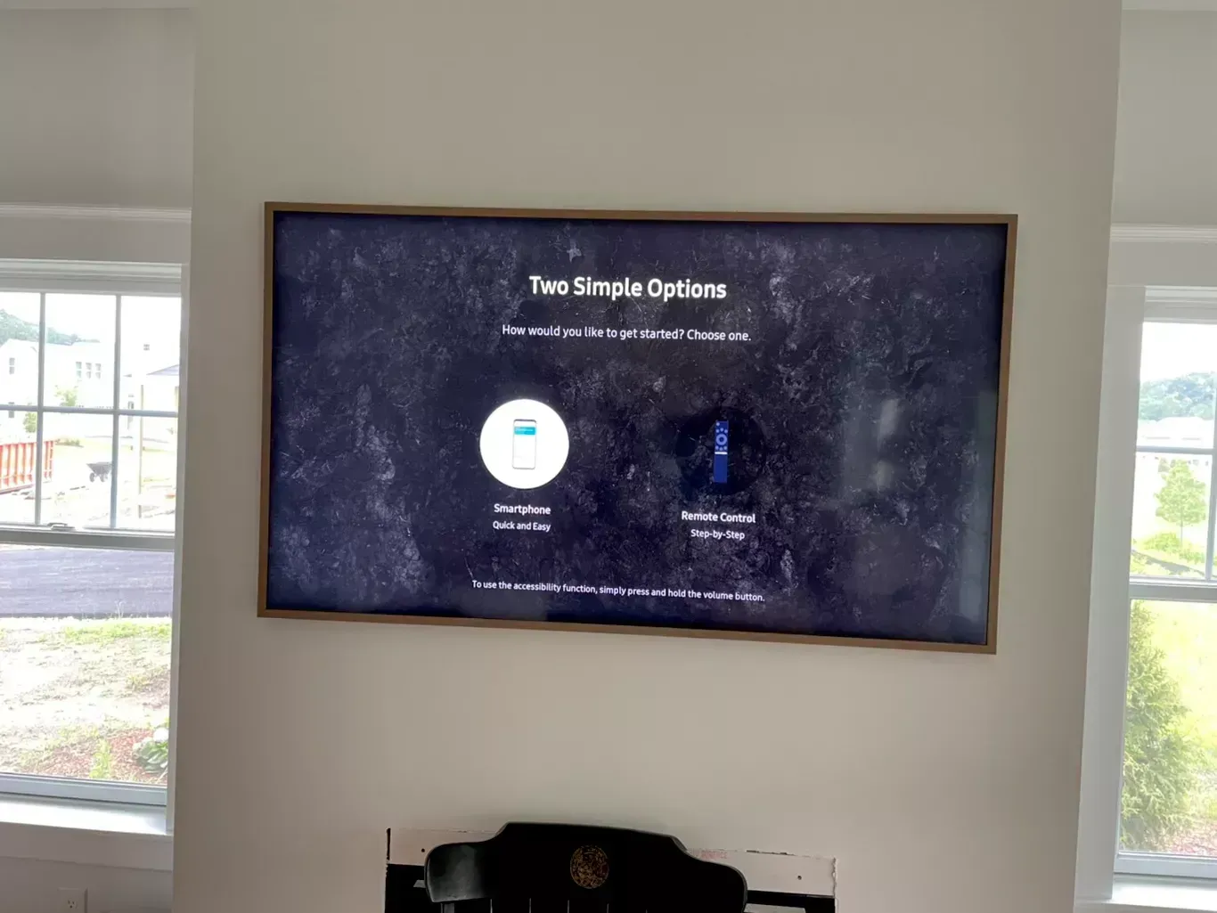 Wall-mounted digital display in a bright room shows a “Two Simple Options” menu.