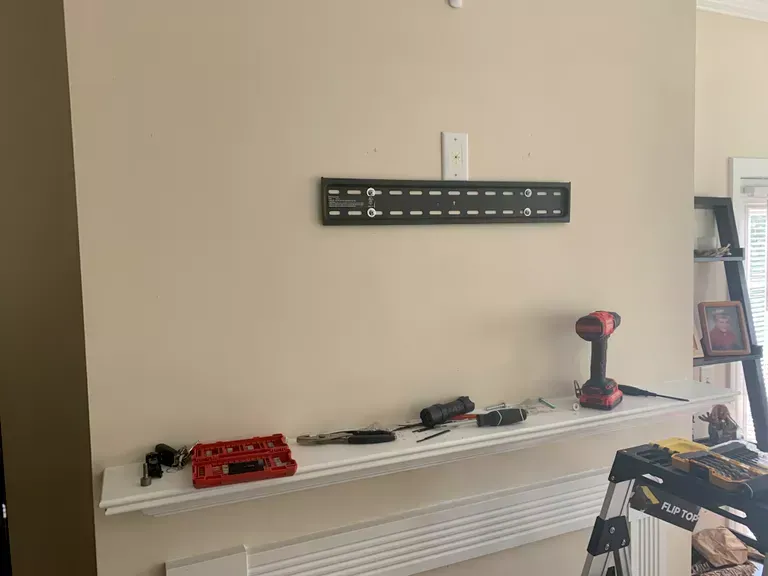 Wall-mounted display with toy cars and a red toy truck on a shelf in a beige room.