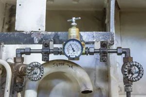 Industrial piping with pressure gauges and valves mounted on a wall