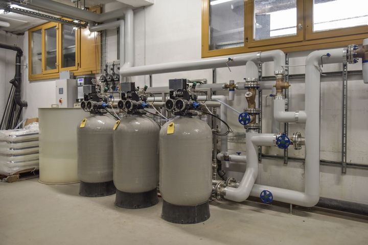 Industrial water filtration tanks and piping in a utility room