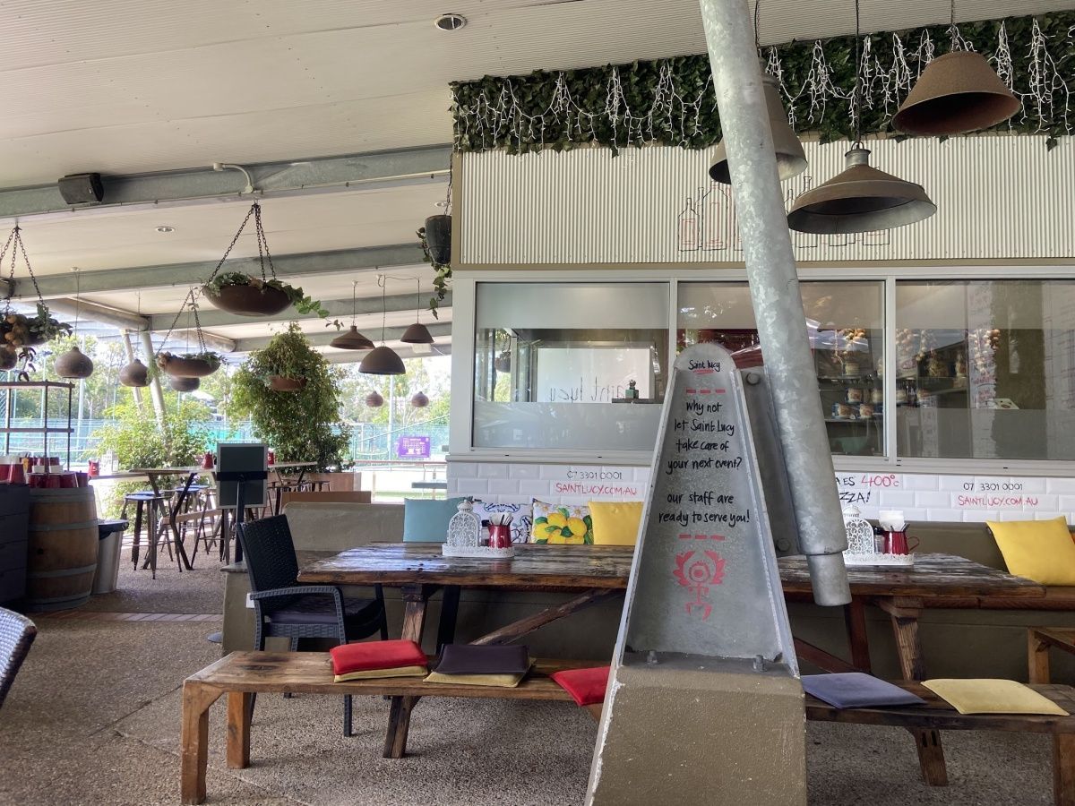 A restaurant with tables and chairs and a sign that says welcome