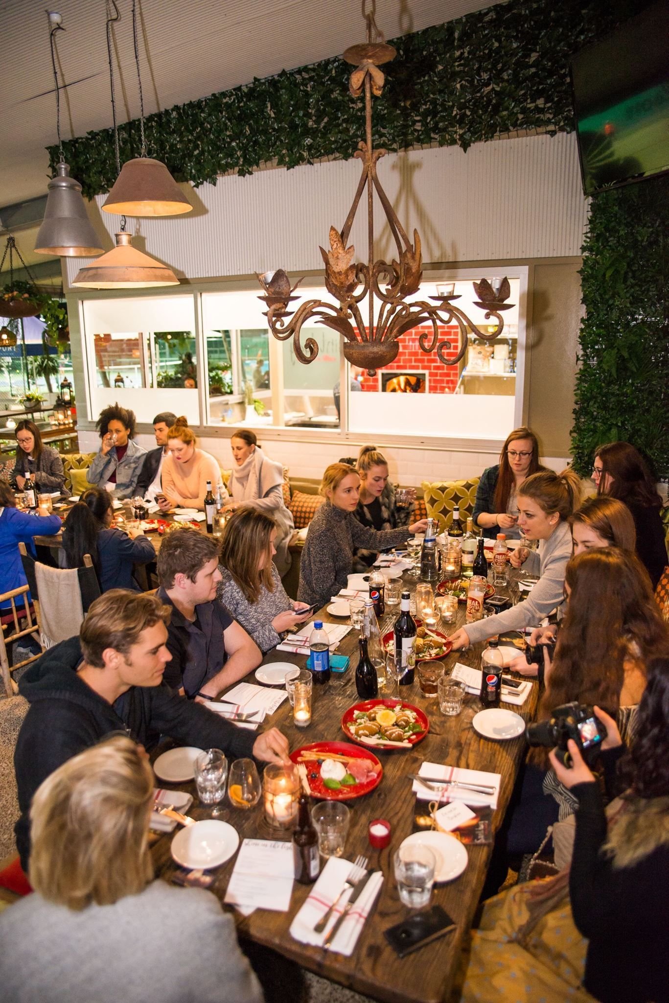 A group of people are sitting at a long table in a restaurant.