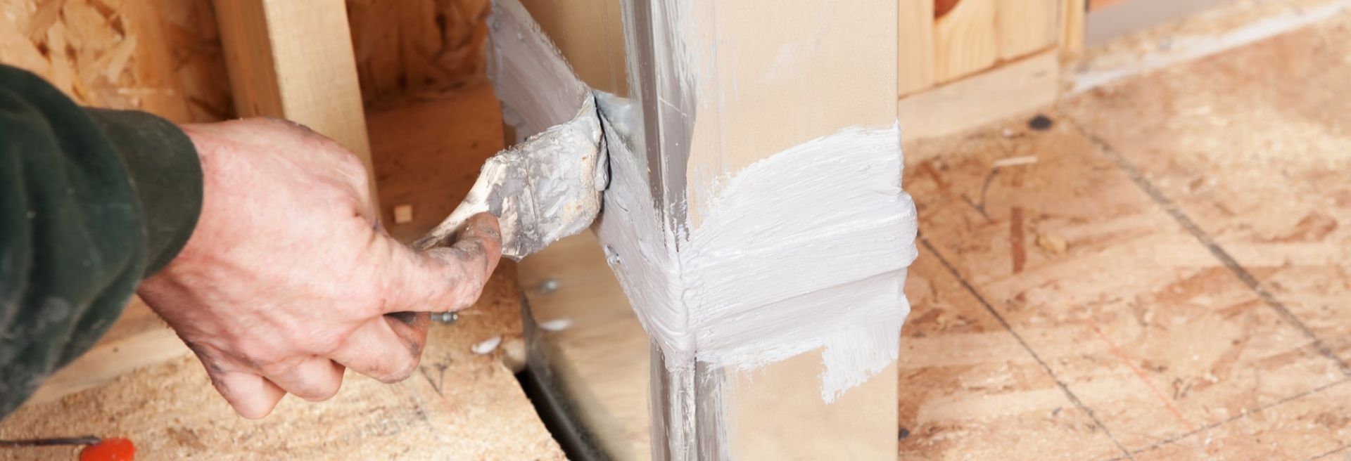 a man is using a spatula to repair an air duct.