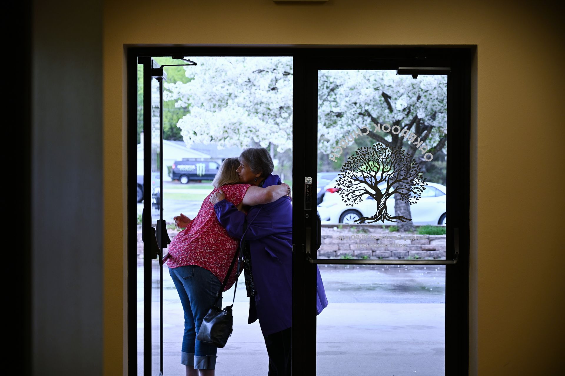 A group of people are standing in front of a window