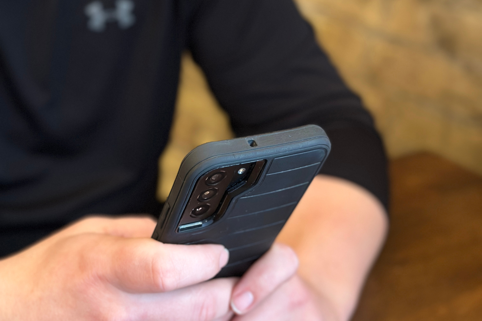 A person is holding a cell phone in their hand.
