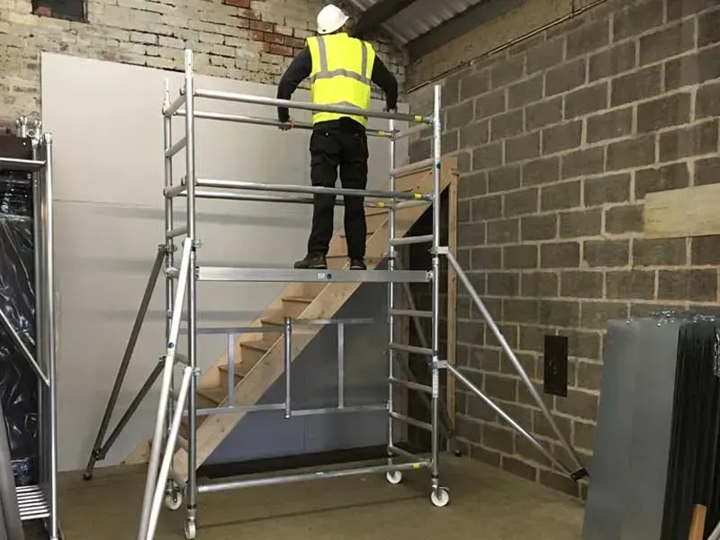 Person on a Mobile Scaffold Wearing a Safety Vest and Hard Hat — Mount Isa Hire Service & Sales in Mount Isa City, QLD