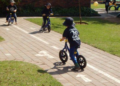 a boy wearing a number 28 shirt is riding a bike