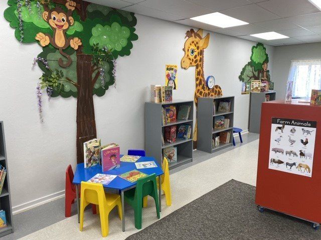 a children 's room with tables and chairs and a sign that says farm animals