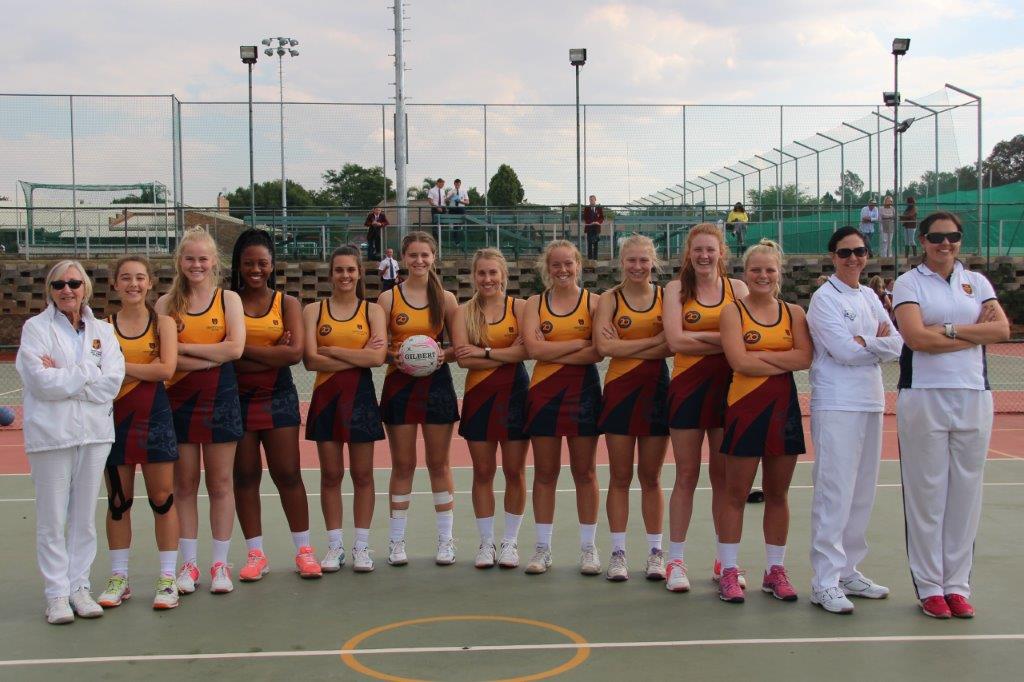 a group of girls standing on a court with their arms crossed