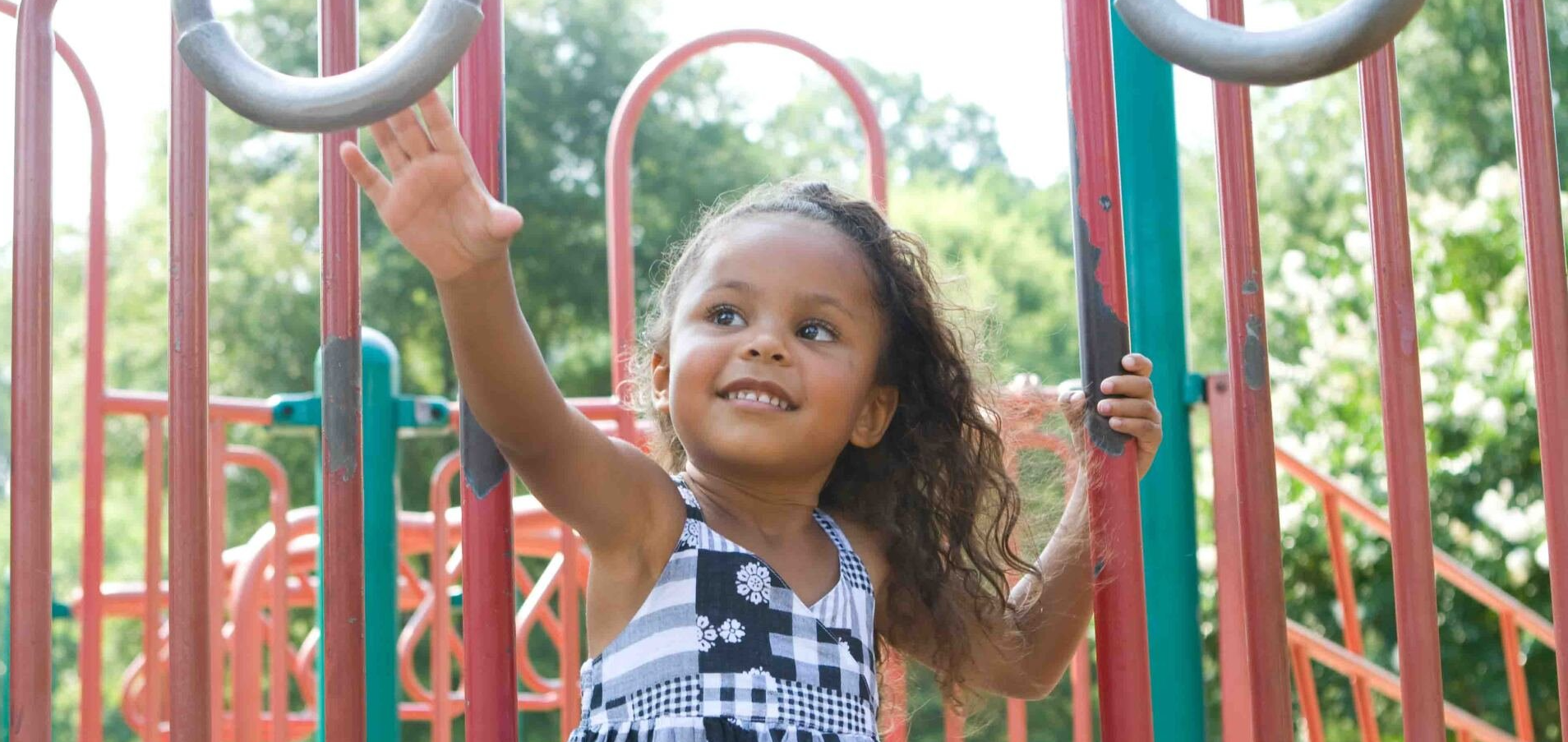A little girl is playing on a playground.