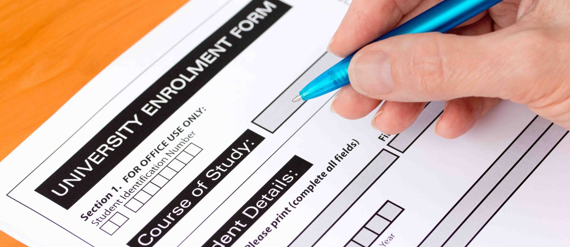 A person is filling out a university enrolment form