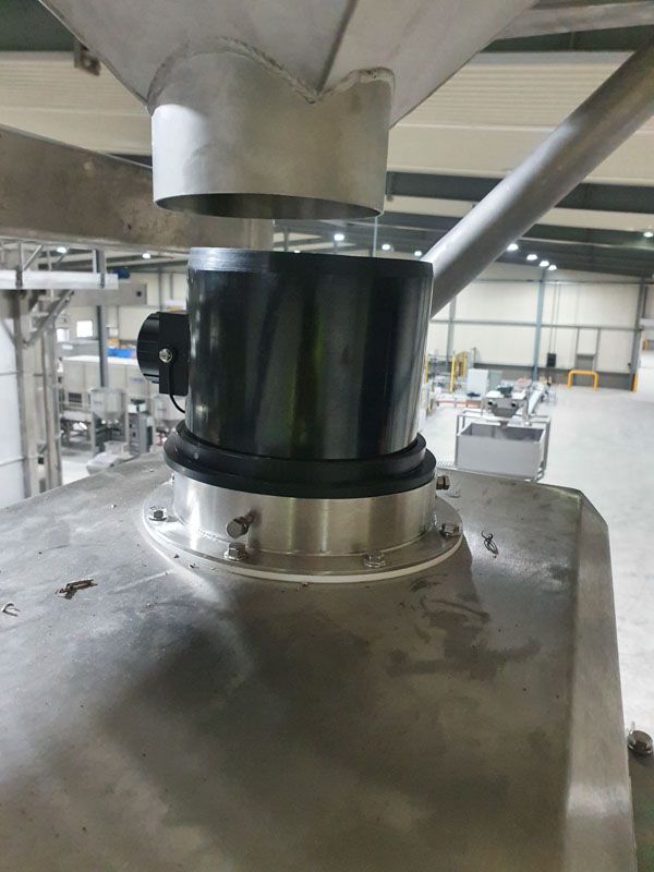 A close up of a stainless steel machine in a warehouse.
