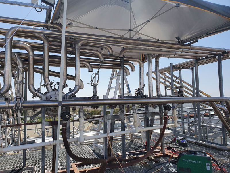 A bunch of pipes are sitting on top of a metal structure.