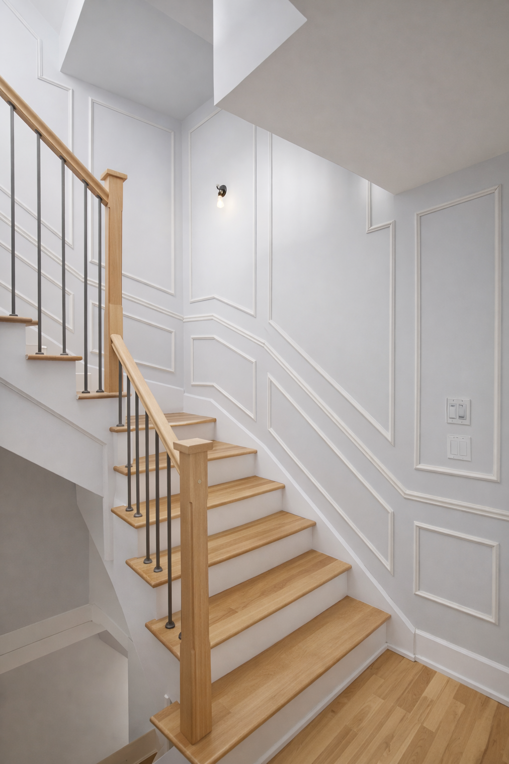 Escalier peint en blanc avec marches et rampe en bois clair dans un couloir lumineux