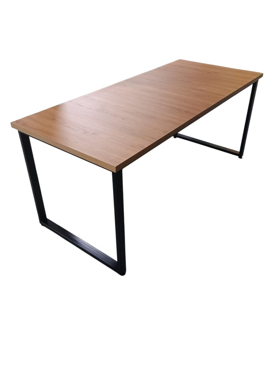 Escritorio rectangular de madera con patas de metal negro sobre fondo blanco.