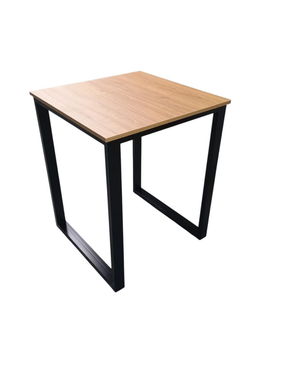 Mesa pequeña cuadrada con tablero de madera clara y patas de metal negro sobre fondo blanco.