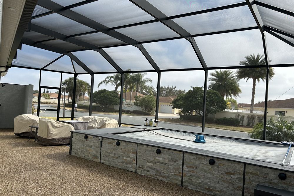 A screened in area with a swimming pool in the background