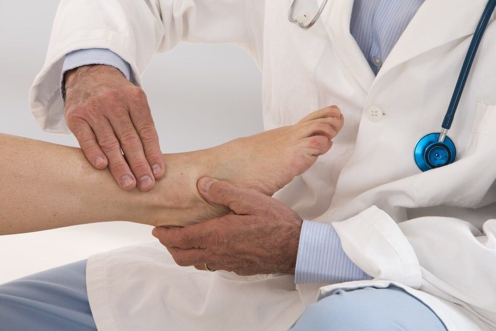A Doctor Is Examining A Patient's Foot With A Stethoscope — Southern Districts Physiotherapy & Sports Injuries Clinic In Tullimbar, NSW