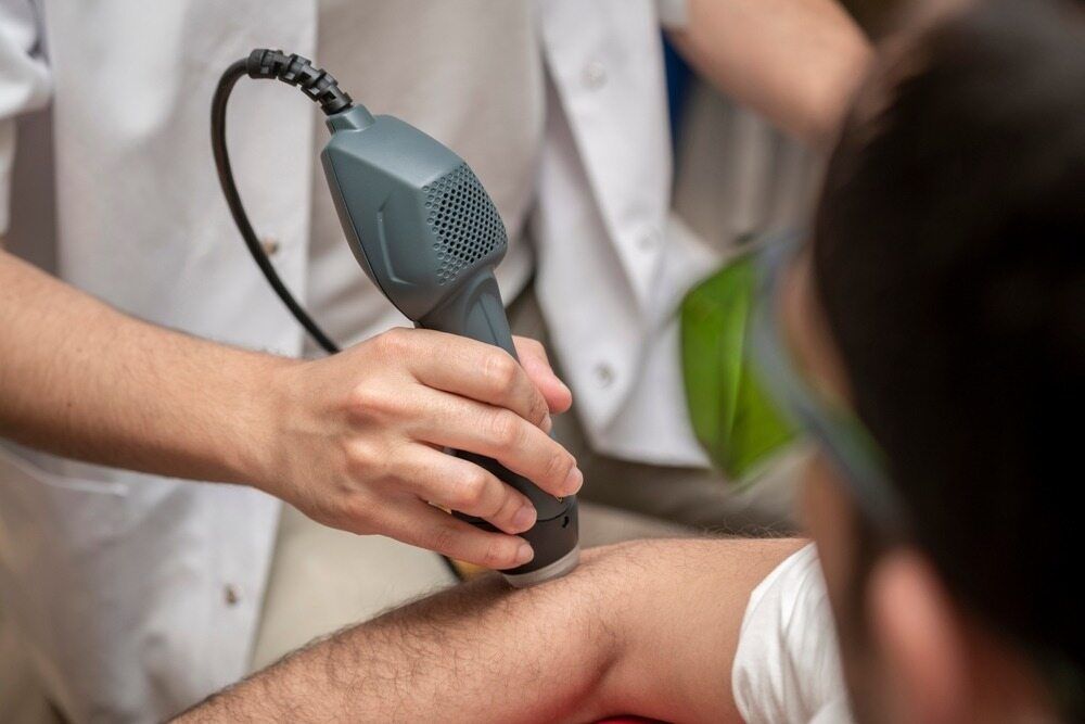 A Person Is Getting A Laser Treatment On Their Arm — Southern Districts Physiotherapy & Sports Injuries Clinic In Albion Park, NSW