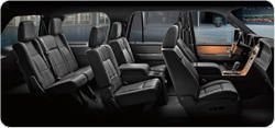 The interior of a ford expedition with a lot of seats and a steering wheel.