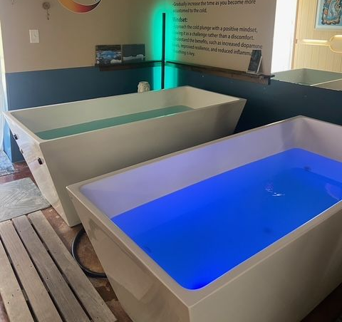 A bathroom with a sauna and a bathtub filled with water.