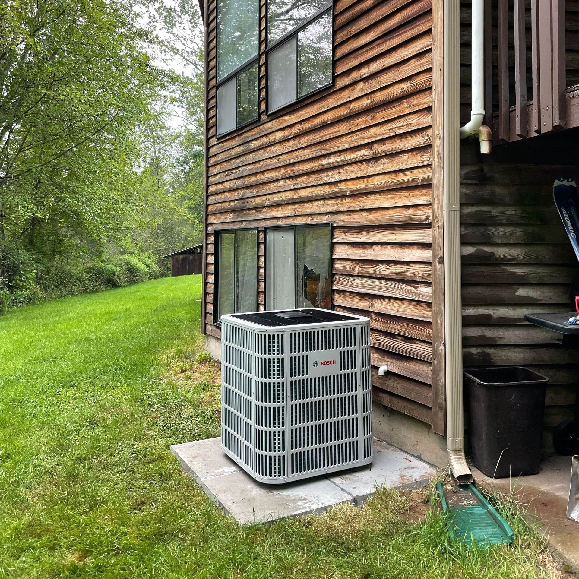 An air conditioner is sitting on the side of a house.