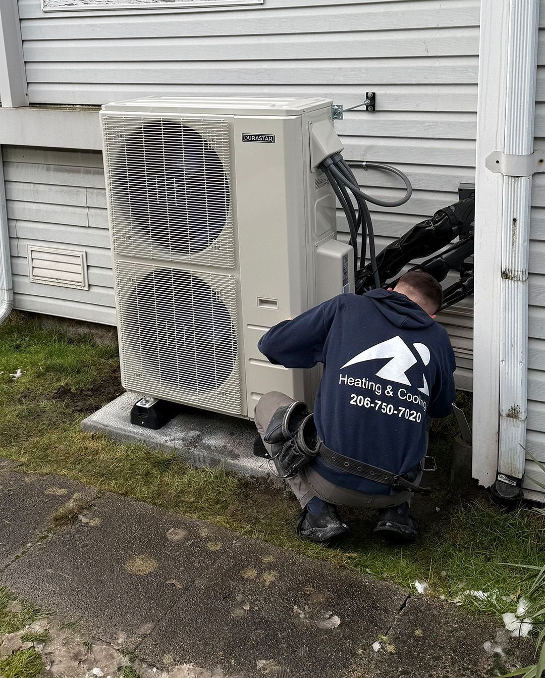 A Ready Energy Solutions Technician is working on an air conditioner outside of a house.