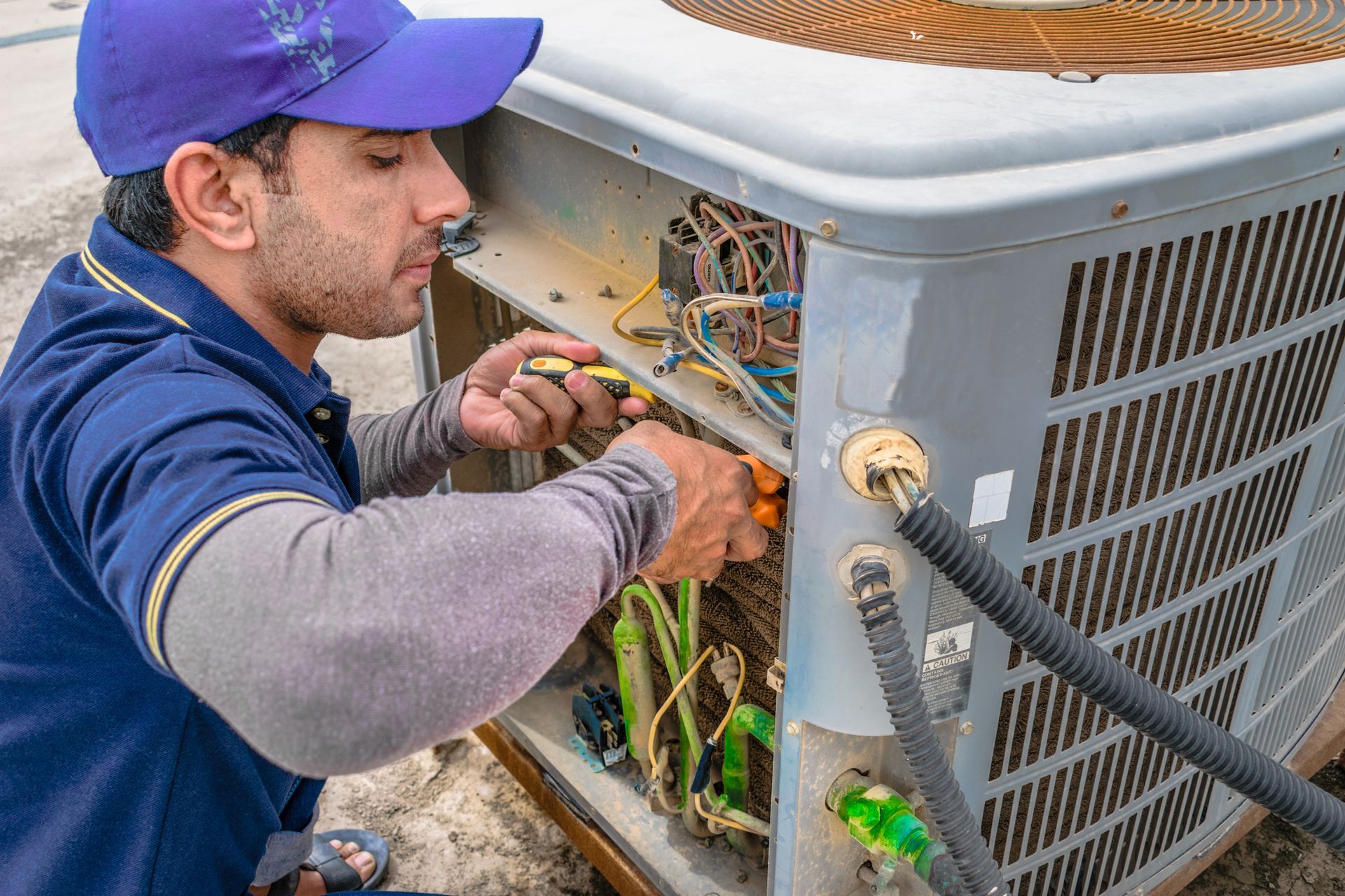 HVAC technician installing new residential heating and cooling system during spring HVAC upgrade.