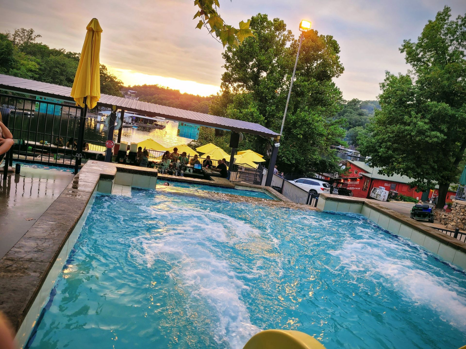 A large swimming pool with a yellow umbrella in the background