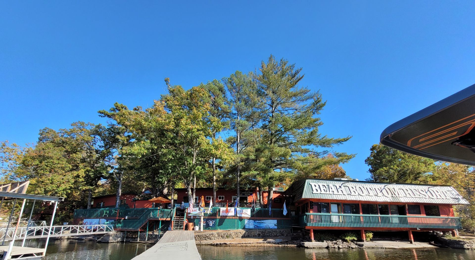 A large house is sitting on the shore of a lake next to a dock.