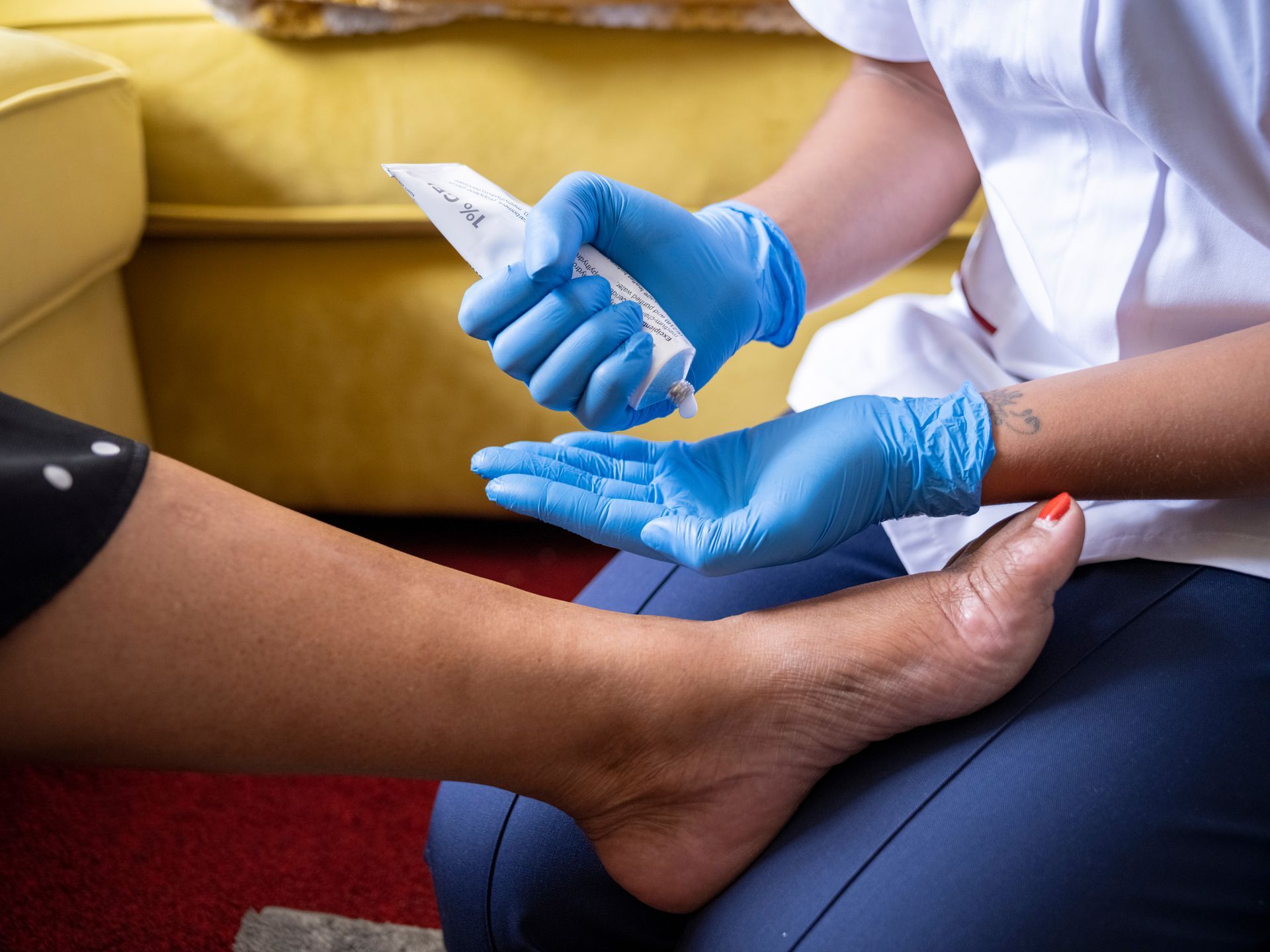 A close-up of a nurse taking care of a woman's foot. A close-up of a nurse taking care of a woman's foot.