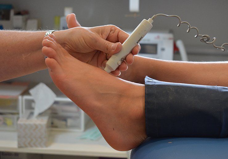 A person's foot being examined with a medical device, presumably for a health check.