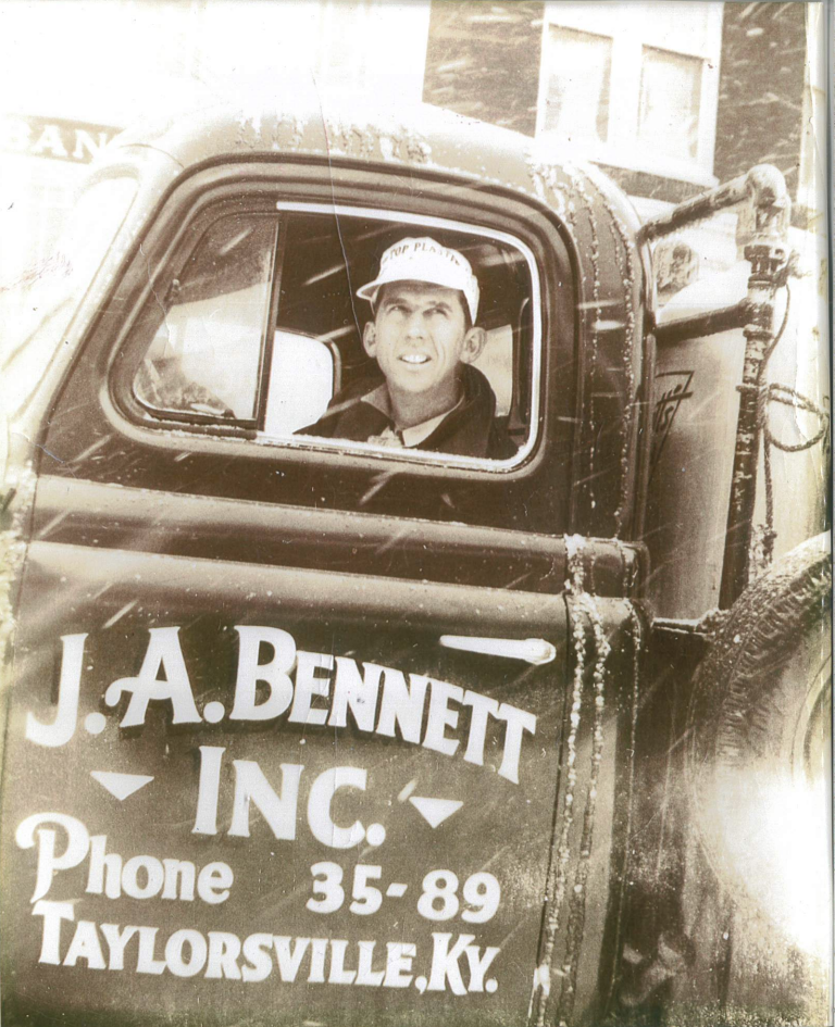 Man in a J.A. Bennett Inc. truck in Taylorsville, KY. The truck door reads “Phone 35-89.” Snowy conditions are present.