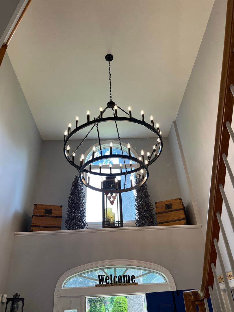 A large chandelier is hanging from the ceiling in a hallway.