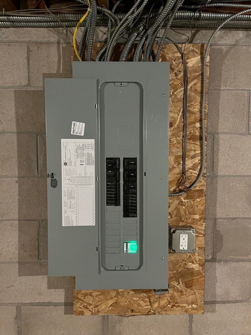 A electrical box is hanging on a brick wall.