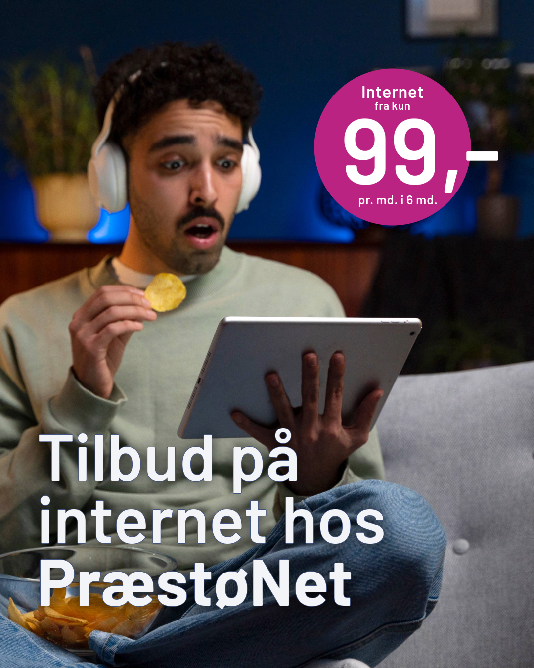 En man der sidder på en blå sofa og har en fjernbetjening i hånden