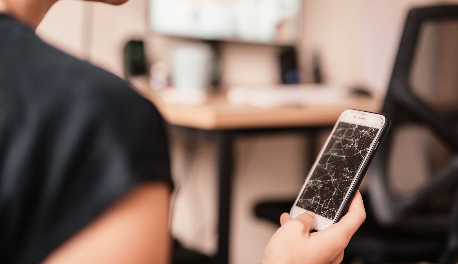 Ung kvinde sidder på sofa og kigger på sin mobiltelefon