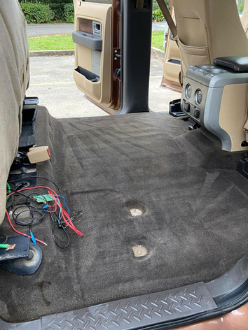 The back seat of a car with a lot of wires coming out of it.