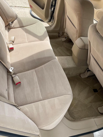 The back seat of a car with the door open