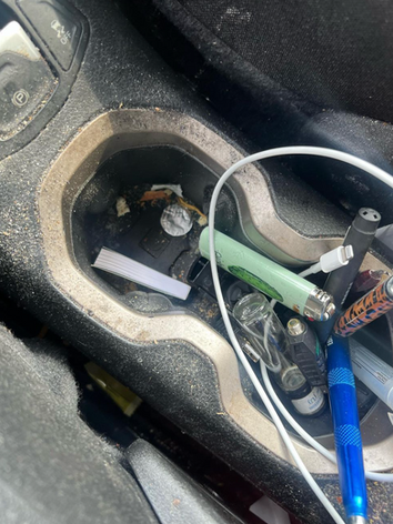 A car dashboard with a bunch of objects in it.