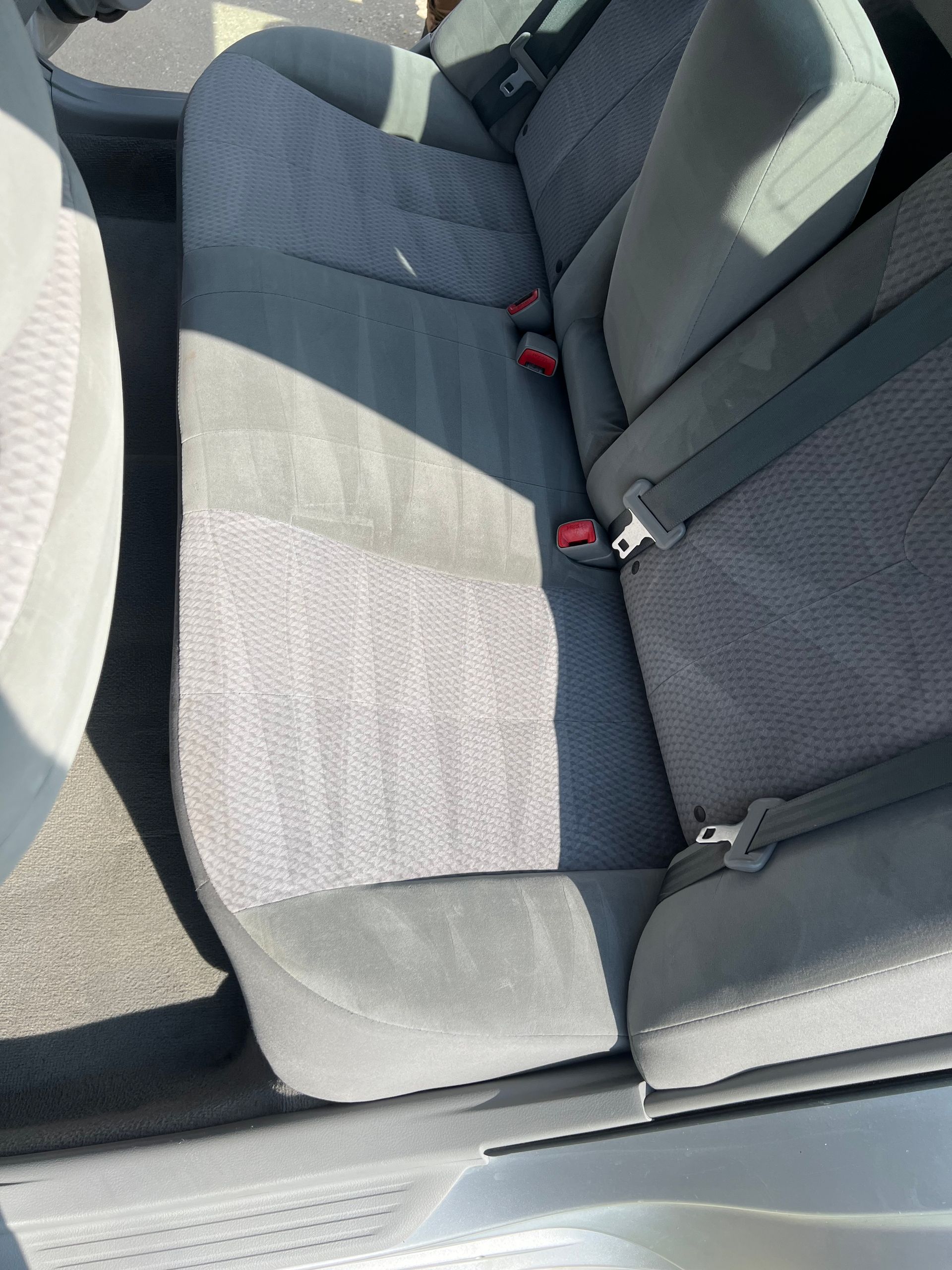 The back seat of a car with a seat belt on it