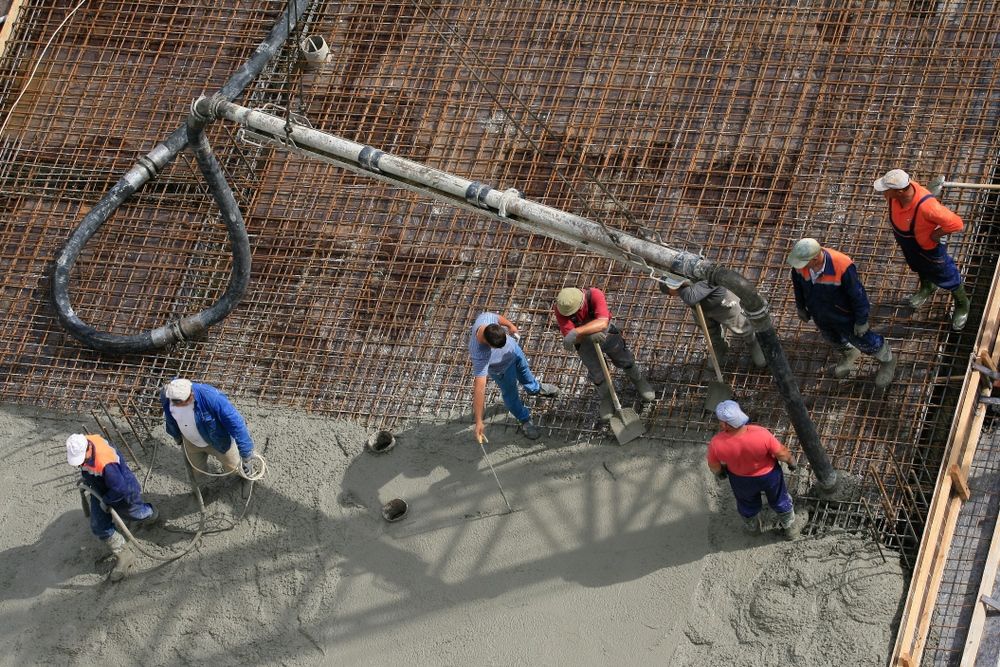 A Group of Construction Workers Are Working on a Concrete Floor — Knobel Builders In Balgownie, NSW
