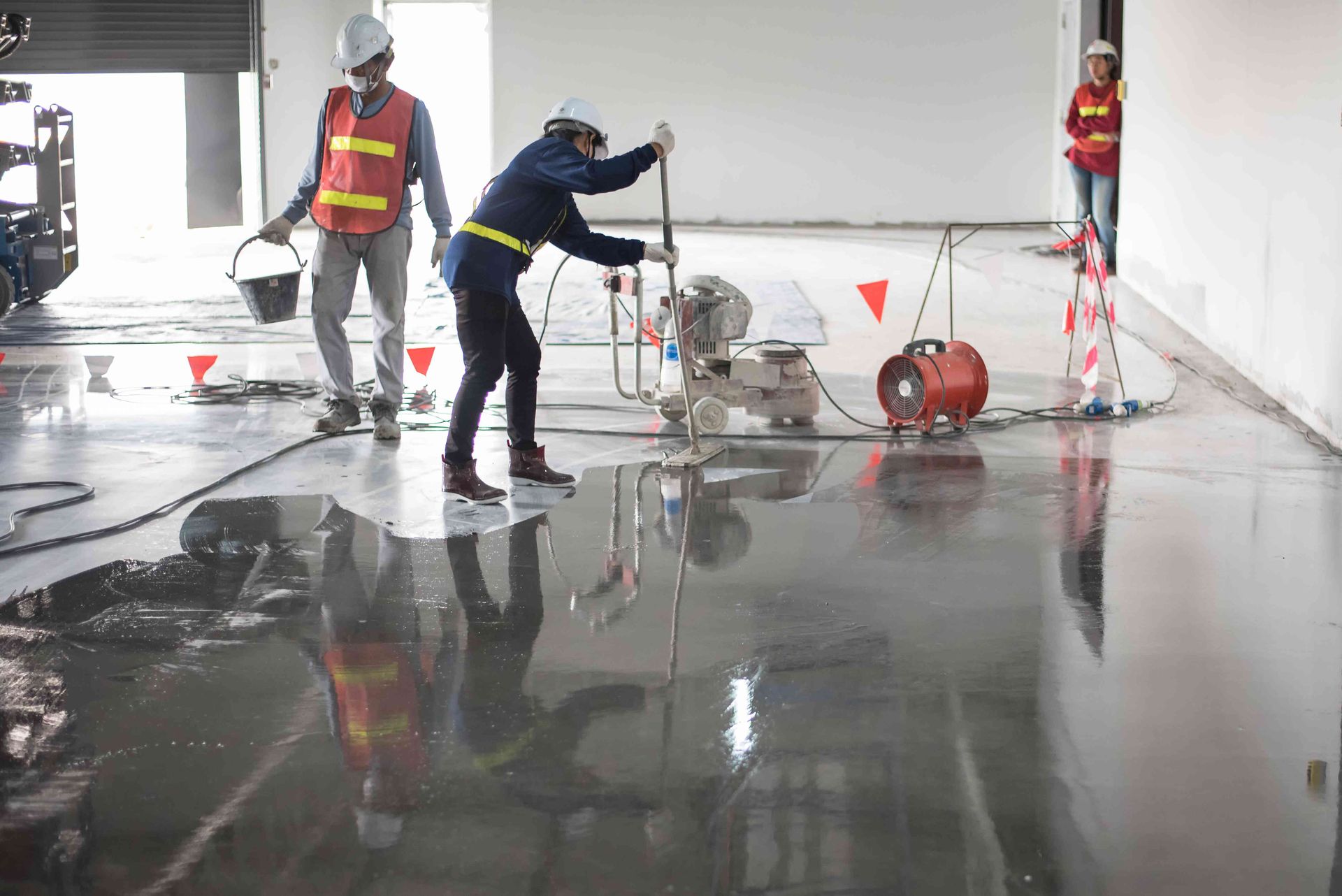 A Group of Construction Workers Are Working on a Concrete Floor — Knobel Builders In Balgownie, NSW