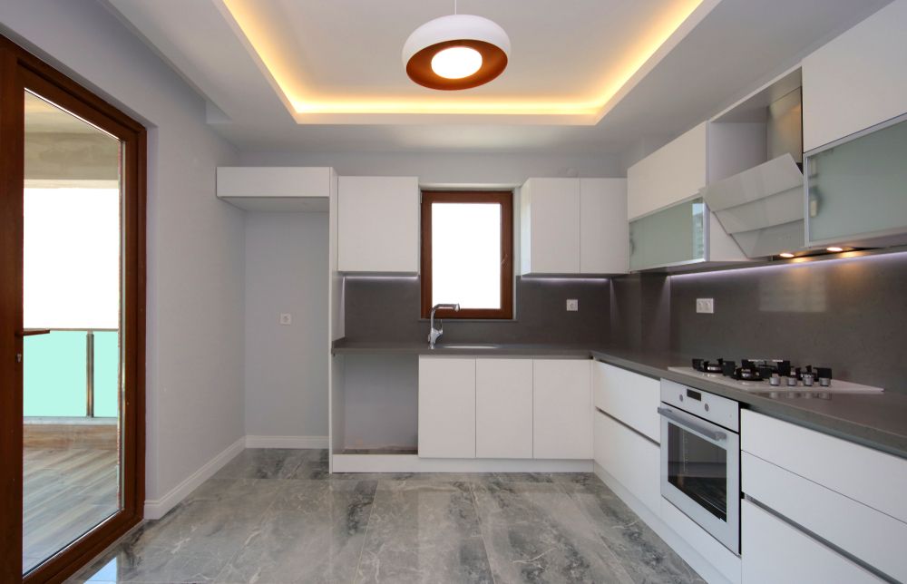 A Kitchen With White Cabinets and Stainless Steel Appliances — Knobel Builders In Shellharbour, NSW
