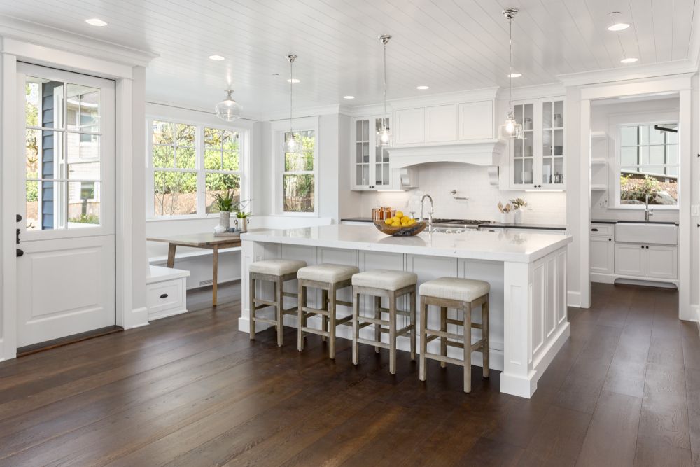A Kitchen in a New Home With White Cabinets and Hardwood Floors — Knobel Builders In Dapto, NSW
