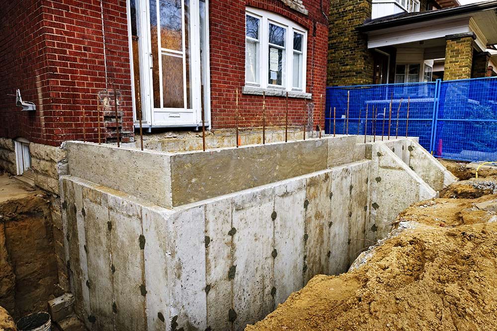 A Brick House With a Concrete Basement Under Construction — Knobel Builders In Balgownie, NSW