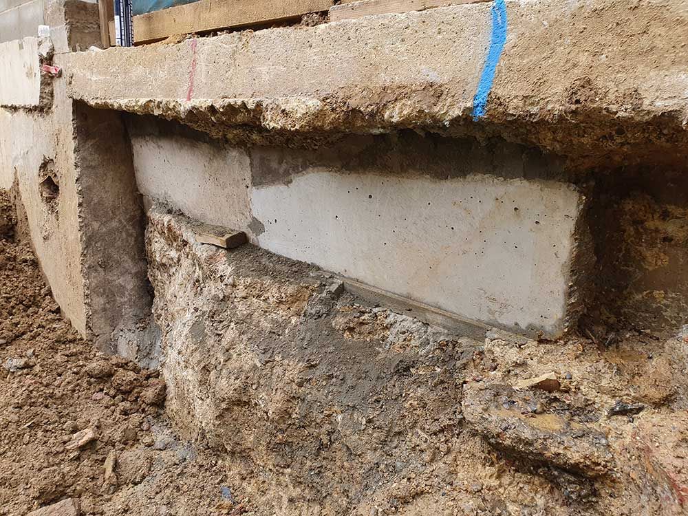 A Piece of Concrete is Sitting on Top of a Pile of Dirt — Knobel Builders In Woonona, NSW