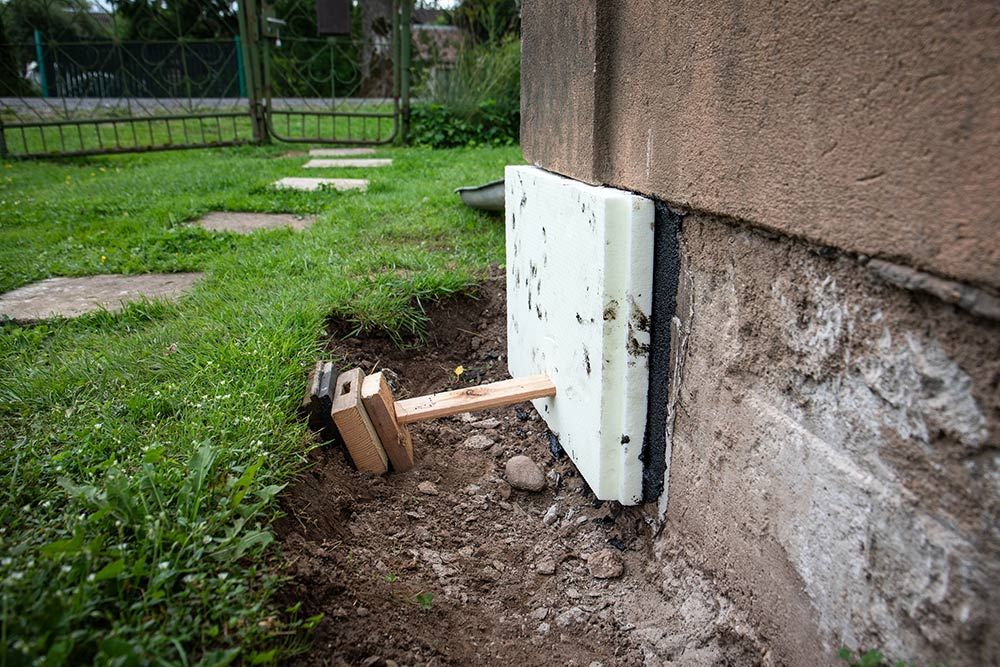 A Hammer is Sitting Next to a Piece of Styrofoam on the Side of a Building — Knobel Builders In Woonona, NSW