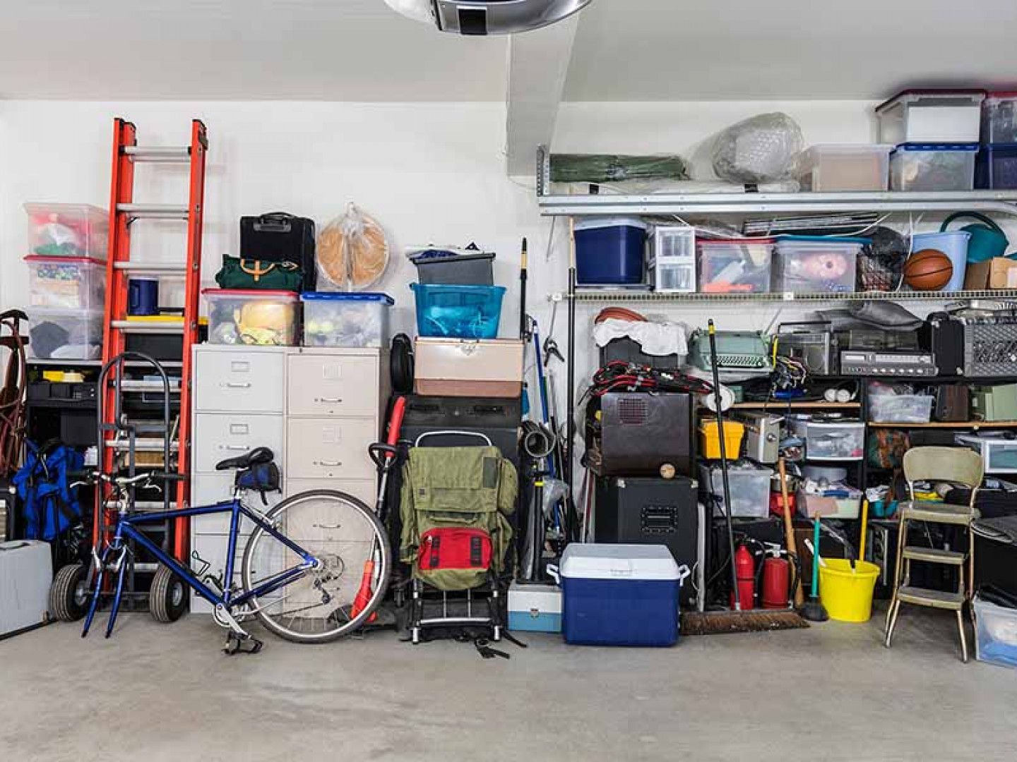A garage filled with lots of items and a bicycle.